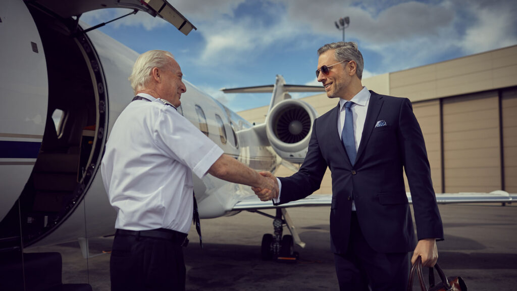 Business man shakes hands with a Cirrus Aviation pilot who is committed to the highest aviation safety standards
